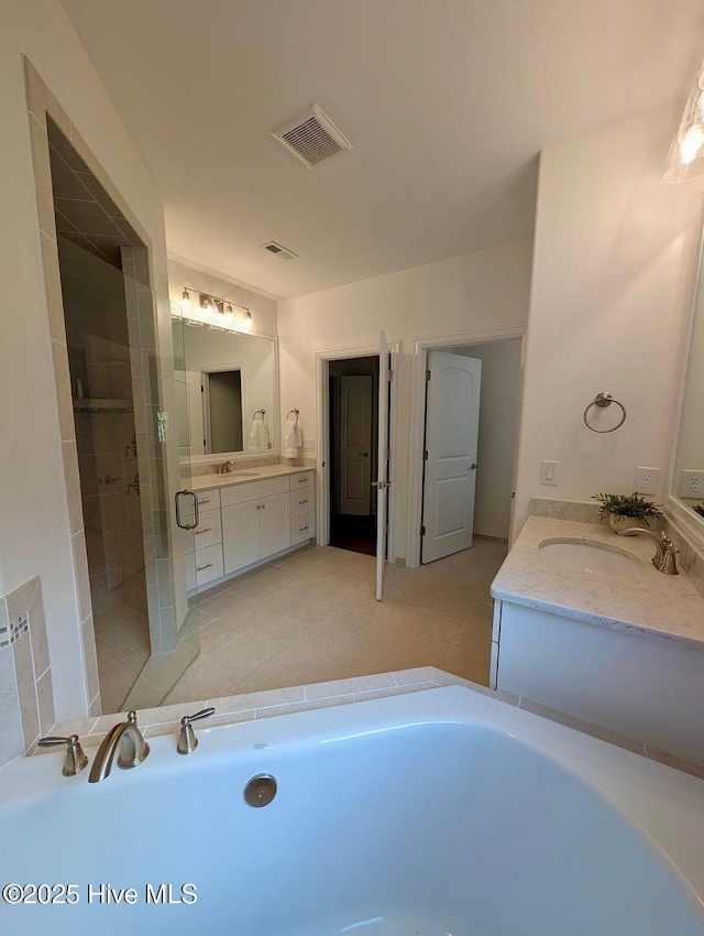 bathroom with a bath, a sink, two vanities, a stall shower, and visible vents