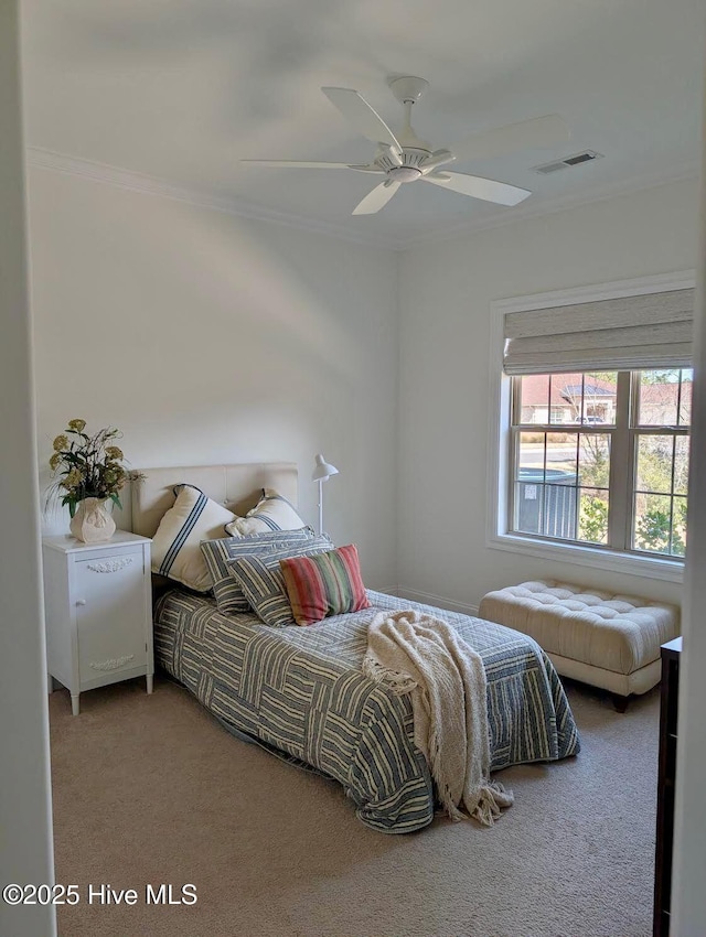 bedroom with a ceiling fan, visible vents, carpet, and ornamental molding