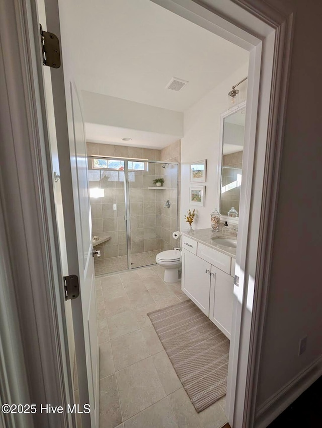 bathroom featuring tile patterned floors, a stall shower, toilet, visible vents, and vanity