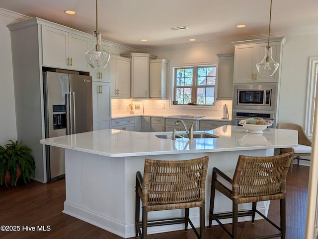 kitchen featuring a sink, stainless steel appliances, backsplash, dark wood-style flooring, and visible vents