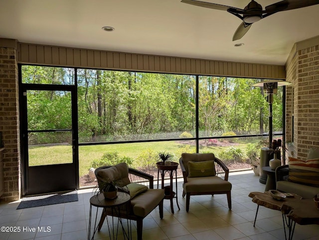 sunroom / solarium featuring a healthy amount of sunlight and ceiling fan