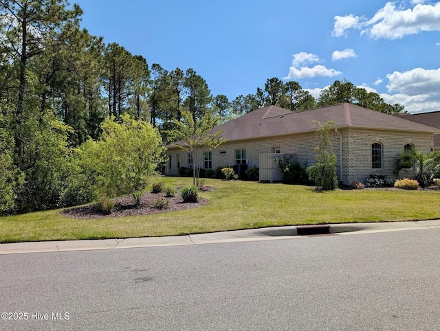 view of front of home with brick siding and a front yard