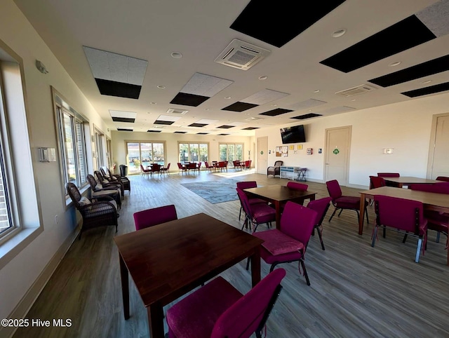 dining area with wood finished floors, visible vents, and baseboards