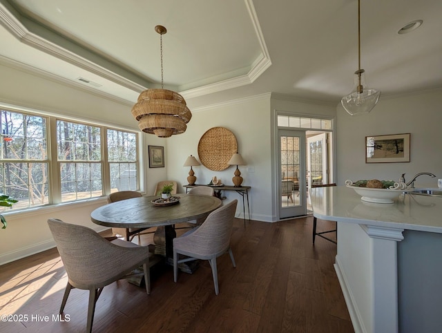 dining space featuring crown molding, visible vents, a raised ceiling, baseboards, and dark wood-style floors