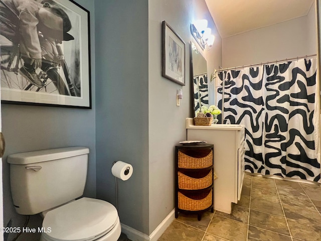 1120 S 3rd St, Wilmington, NC 28401 - bathroom featuring toilet, vanity, baseboards, stone finish flooring, and a shower with shower curtain