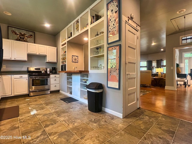 1120 S 3rd St, Wilmington, NC 28401 - kitchen featuring stainless steel gas stove, open shelves, dark countertops, baseboards, and white cabinetry