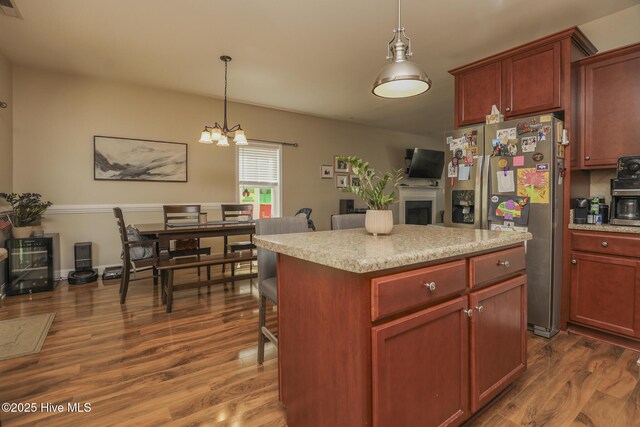 202 Peggys Trce, Sneads Ferry, NC 28460 - kitchen with pendant lighting, a chandelier, stainless steel fridge with ice dispenser, a fireplace, and dark wood-type flooring