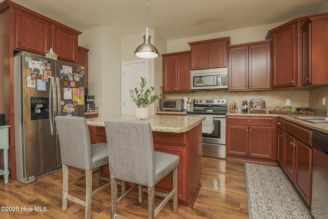 202 Peggys Trce, Sneads Ferry, NC 28460 - kitchen with backsplash, a kitchen island, appliances with stainless steel finishes, and dark wood finished floors