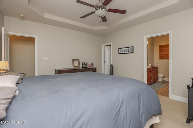 202 Peggys Trce, Sneads Ferry, NC 28460 - bedroom with baseboards, a raised ceiling, ensuite bath, ceiling fan, and light carpet