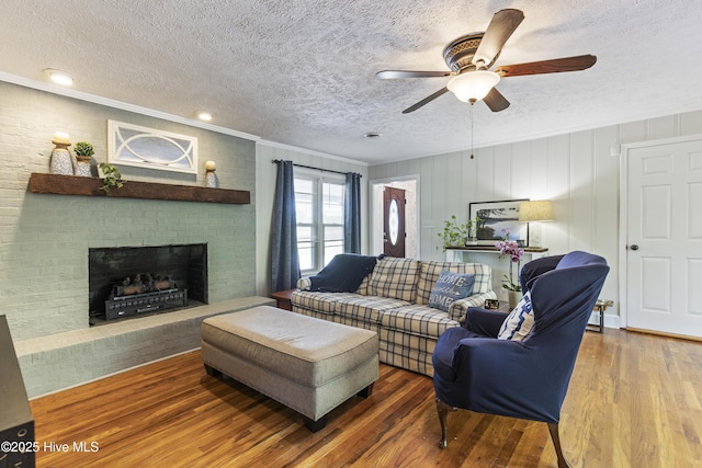 living area with wood finished floors, a textured ceiling, and ceiling fan