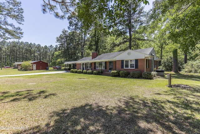 single story home featuring brick siding, cooling unit, a chimney, and a front yard