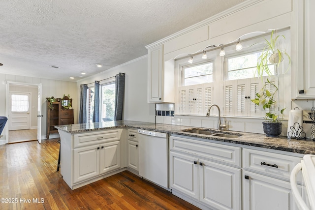kitchen with a wealth of natural light, range, white dishwasher, and a sink