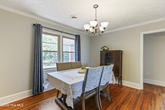 dining space featuring dark wood-style floors, a textured ceiling, a chandelier, and ornamental molding