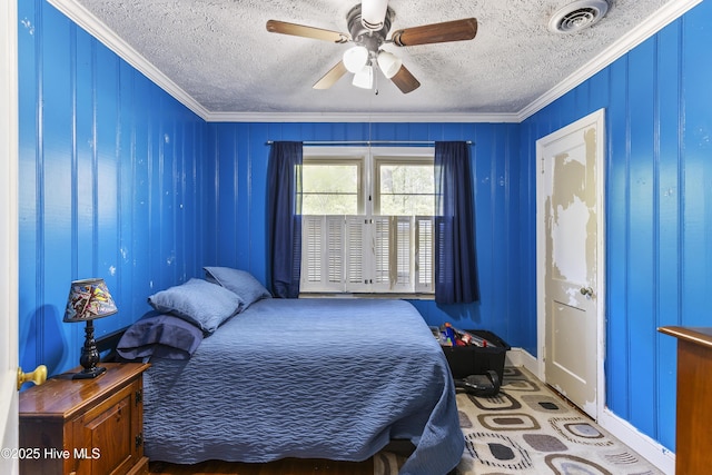 bedroom with a ceiling fan, visible vents, a textured ceiling, and crown molding