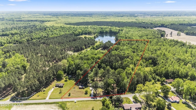 aerial view featuring a forest view and a water view