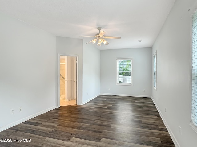 empty room with ceiling fan, dark wood finished floors, and baseboards