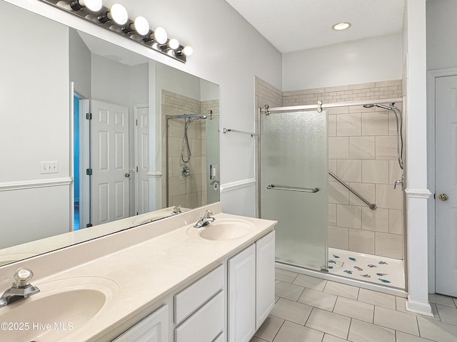 bathroom with a stall shower, double vanity, and tile patterned floors