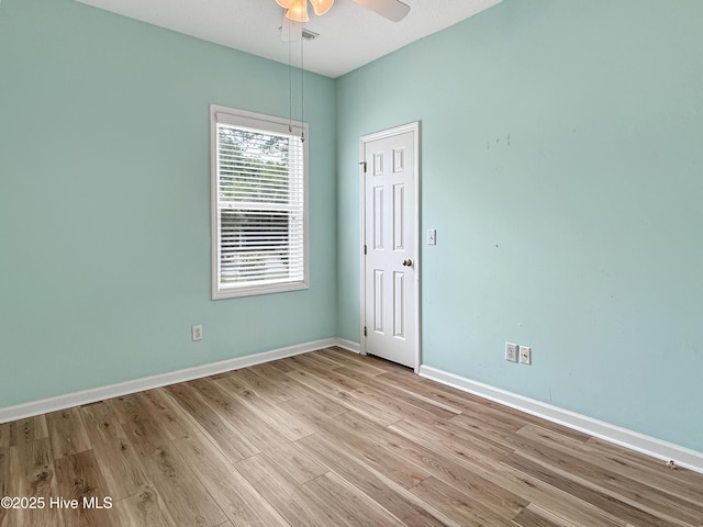 unfurnished room featuring ceiling fan, light wood finished floors, and baseboards