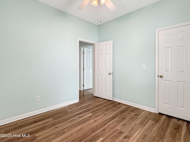 unfurnished bedroom featuring wood finished floors, baseboards, and ceiling fan