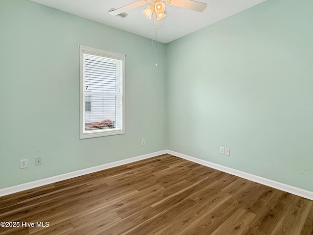unfurnished room with wood finished floors, baseboards, and a ceiling fan