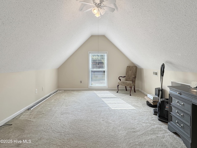 additional living space featuring a textured ceiling, carpet, ceiling fan, lofted ceiling, and baseboards