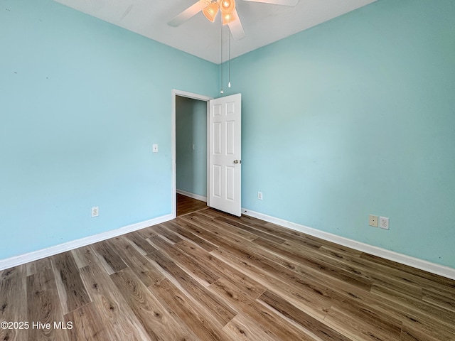 spare room featuring baseboards, a ceiling fan, and wood finished floors
