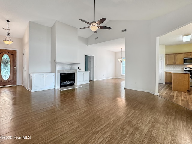 unfurnished living room featuring ceiling fan, high vaulted ceiling, dark wood-style floors, a fireplace, and baseboards
