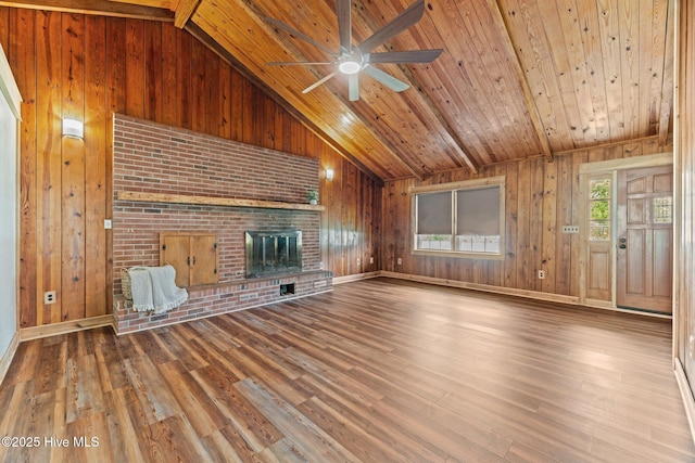 1450 State Camp Rd, Vanceboro, NC 28586 - unfurnished living room with vaulted ceiling, wooden ceiling, a ceiling fan, a brick fireplace, and wood walls