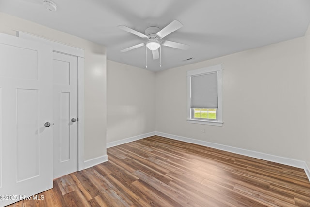 1450 State Camp Rd, Vanceboro, NC 28586 - unfurnished bedroom with baseboards, wood finished floors, and a ceiling fan