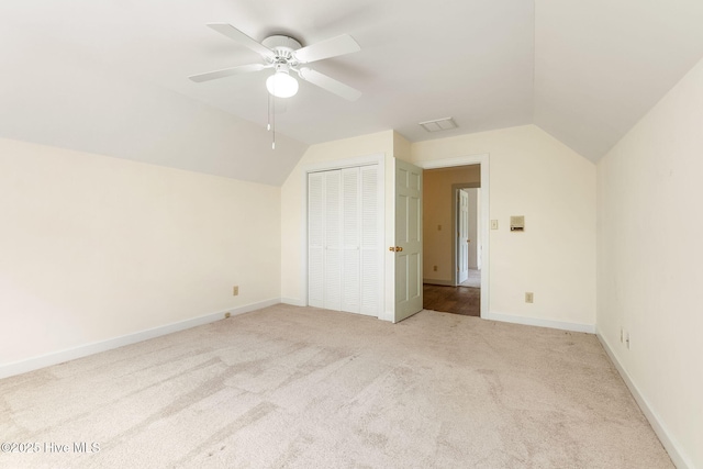 additional living space with light colored carpet, a ceiling fan, and vaulted ceiling