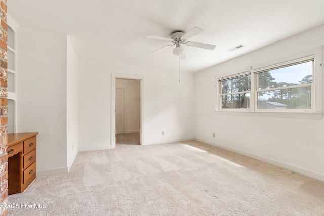 unfurnished bedroom featuring light colored carpet, baseboards, visible vents, and a ceiling fan
