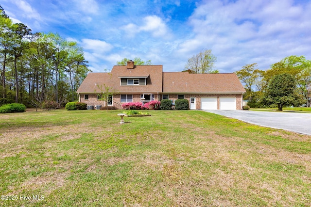 cape cod-style house with a garage, a front yard, a chimney, brick siding, and driveway
