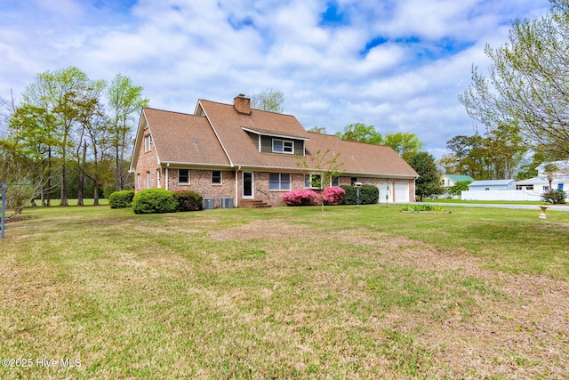 view of front of house featuring an attached garage, cooling unit, a chimney, and a front yard