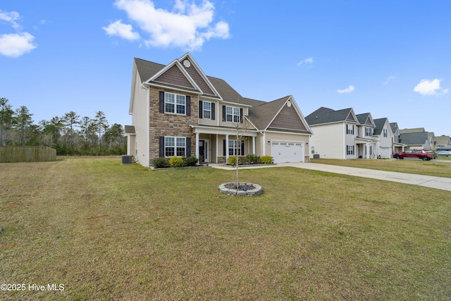 313 March Sea Ln, Jacksonville, NC 28546 - view of front of home featuring stone siding, driveway, a front yard, and covered porch