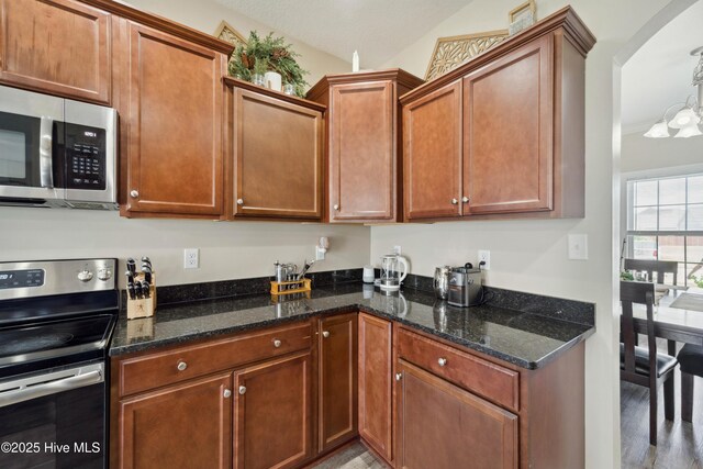 313 March Sea Ln, Jacksonville, NC 28546 - kitchen with appliances with stainless steel finishes, arched walkways, dark stone countertops, and wood finished floors