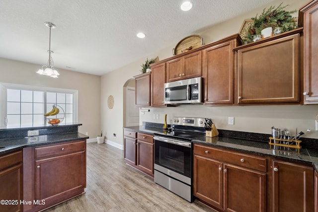 313 March Sea Ln, Jacksonville, NC 28546 - kitchen with appliances with stainless steel finishes, arched walkways, light wood-style floors, hanging light fixtures, and a textured ceiling