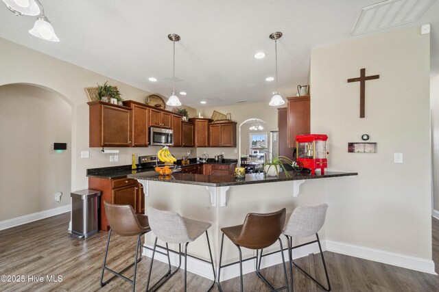 313 March Sea Ln, Jacksonville, NC 28546 - kitchen with appliances with stainless steel finishes, arched walkways, wood finished floors, a peninsula, and recessed lighting