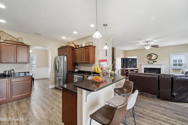 313 March Sea Ln, Jacksonville, NC 28546 - kitchen featuring appliances with stainless steel finishes, open floor plan, arched walkways, a ceiling fan, and a kitchen breakfast bar