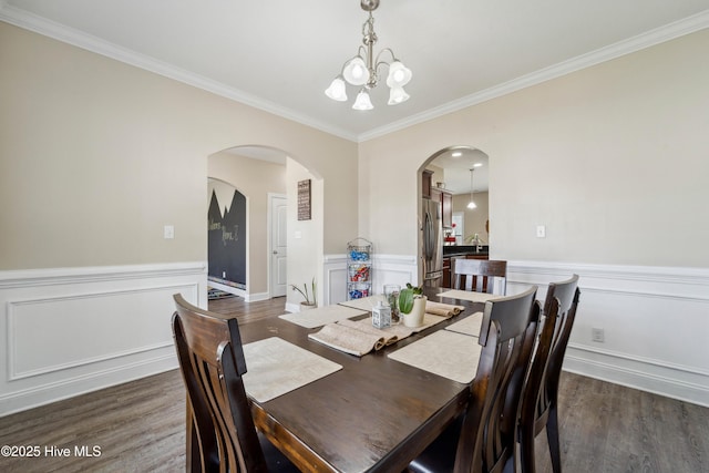 313 March Sea Ln, Jacksonville, NC 28546 - dining area featuring arched walkways, crown molding, a wainscoted wall, wood finished floors, and a chandelier