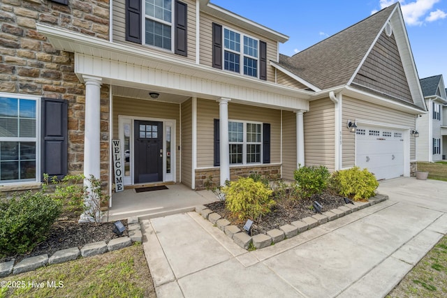 313 March Sea Ln, Jacksonville, NC 28546 - view of front facade with stone siding, a porch, driveway, and an attached garage
