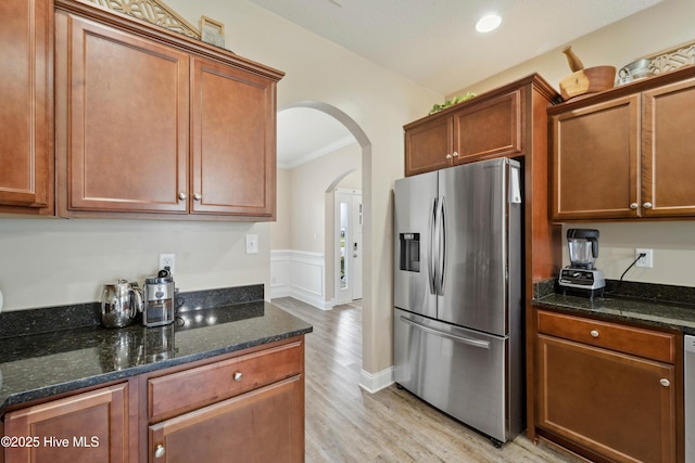 313 March Sea Ln, Jacksonville, NC 28546 - kitchen with appliances with stainless steel finishes, arched walkways, light wood finished floors, ornamental molding, and dark stone countertops