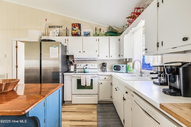 3325 W Beach Dr, Oak Island, NC 28465 - kitchen featuring white appliances, lofted ceiling, under cabinet range hood, white cabinets, and light wood-style floors