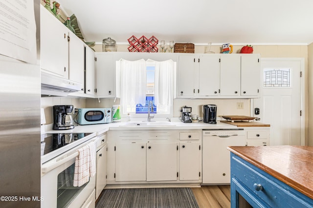 3325 W Beach Dr, Oak Island, NC 28465 - kitchen with white appliances, under cabinet range hood, white cabinets, wood finished floors, and light countertops