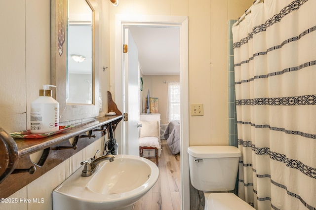 3325 W Beach Dr, Oak Island, NC 28465 - full bathroom with a shower with shower curtain and wood finished floors