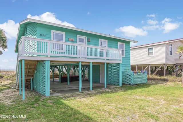 3325 W Beach Dr, Oak Island, NC 28465 - rear view of house with a carport, a lawn, a wooden deck, and stairway