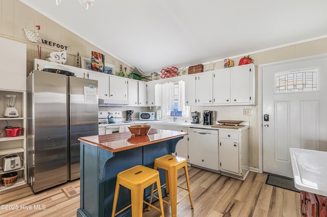 3325 W Beach Dr, Oak Island, NC 28465 - kitchen featuring white appliances, under cabinet range hood, white cabinets, light wood-style flooring, and a center island