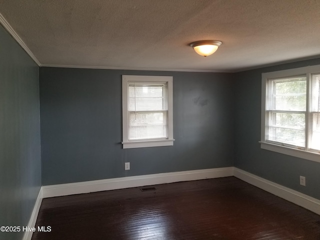 403 Jamesville Rd, Williamston, NC 27892 - spare room featuring crown molding, dark wood-style flooring, baseboards, a textured ceiling, and visible vents