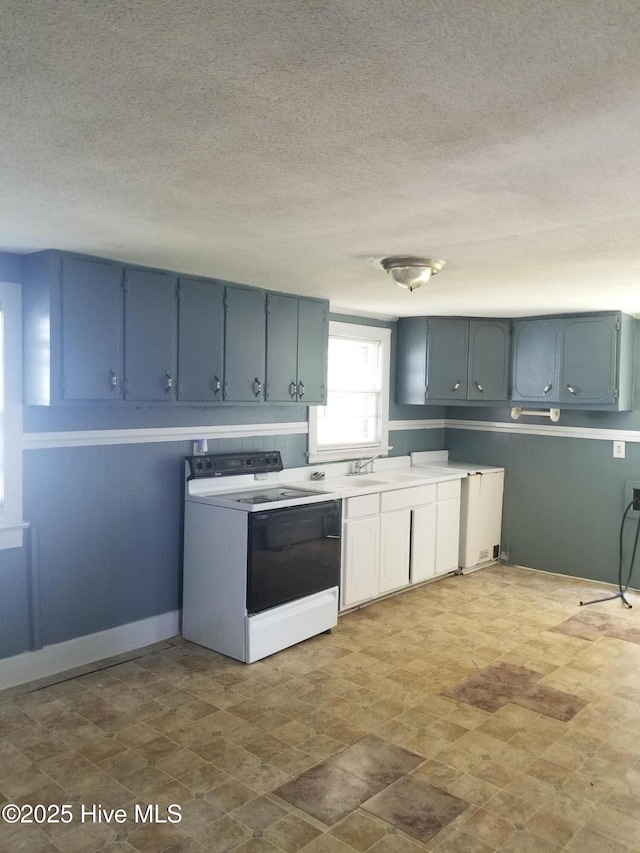 403 Jamesville Rd, Williamston, NC 27892 - kitchen with white electric range oven, a textured ceiling, light countertops, and blue cabinets