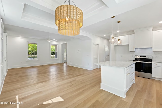 kitchen with baseboards, white cabinetry, a kitchen island, stainless steel electric stove, and arched walkways