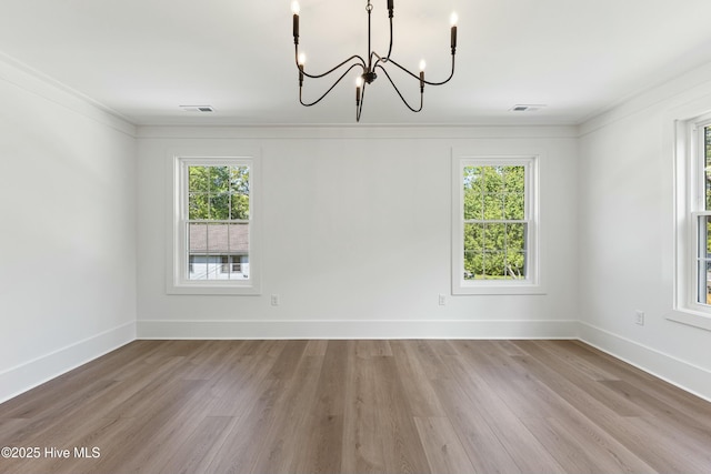 unfurnished dining area featuring a chandelier, visible vents, wood finished floors, and a healthy amount of sunlight